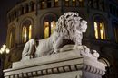 Kveldsbilde av løveskulpturen foran Stortinget. Stortinget har mottatt kritikk for manglende sikkerhet i forkant av dataangrepene i 2020 og 2021.
