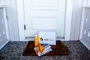 Helthjem-pakke, avis og matvarer på en dørstokk.