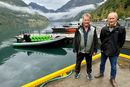 Frank Bonsaksen (t.v.) driver sightseeing i Geirangerfjorden. Her med den gjennomprøvde elbåten i bakgrunnen. Her sammen med Trond Strømgren fra motorleverandør Evoy.