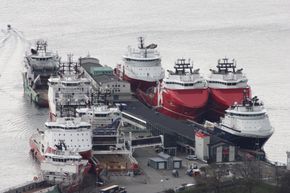 En vanlig situasjon i Bergen: Mange offshoreskip til kai. Alle bruker dieseldrevne generatorer til strømproduksjon. De bidrar til 35 % av de helseskadelige NOx-utslippene fra havna. Ett landstrømpunkt for ett skip er nå satt opp til venstre på kaia. <i>Foto: Bergen og omland havnevesen</i>