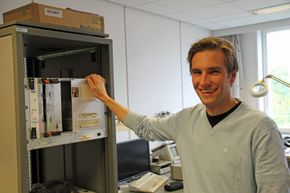Magnus Jahre, som her viser fram maskinvare som benyttes i forbindelse med testing av prosessorer som er designet ved instituttet. <i>Bilde:  Harald Brombach</i>