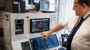 Scott Plimley viser fram den norske operatørkonsollen inne på avionikk-integrasjonstestanlegget, med det nyintegrerte systemet for å finne mobiltelefoner. <i>Foto: Eirik Helland Urke</i>