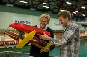 John Martin Kleven Godø (t.v) og Fredrik Storflor Moen med et modellskrog med Flapping Foil ved havbassenget på Marintek. <i>Foto: Torgeir Storflor Moen</i>