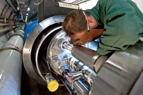 En sveiser fullfører en av de siste koblingene på Large Hadron Collider (LHC) i 2007. <i>Foto: Maximilien Brice/CERN</i>