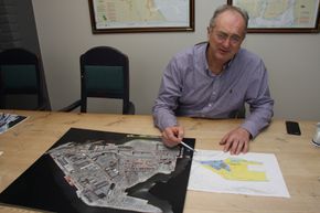 Einar Olsen med flyfoto av havna og tegning med planer for neste utfylling. Bukta på bildet skal fylles og øker arealet med 75.000 kvadratmeter. <i>Foto: Tore Stensvold</i>
