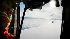 Svalbard har to redningshelikoptere stasjonert i Longyearbyen. Her ser vi også Sysselmannens skip Polarsyssel ved iskanten. <i>Foto:  Eirik Helland Urke</i>