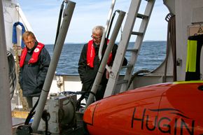 Hugin gjøres klar for et nytt dykk på jakt etter miljøsyndere og kanskje nye skatter. Svein Almedal og Roars Jonstang følger med AUV-operatør Espen Stange fra Kongsberg Maritime. <i>Foto: Tore Stensvold</i>