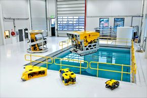 Kystdesigns undervannsroboter i ulike varianter. Til venstre på gulvet foran bassenget ligger den nye notvaskeren. De to minste robotene er observasjons-ROV&#039;er som produseres hos Ocean Robotics i Sverige. Erik Bakkevig eier 25 prosent av bedriften. <i>Foto: Kystdesign</i>