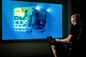 Tester: I det nye testbassenget kan pilot Joakim Krokedal Slettemeås, følge med gjennom vinduet hvordan roboten oppfører seg i virkeligheten ikke bare via en monitor. <i>Foto: Torbjørn Steinagard, Kystdesign</i>