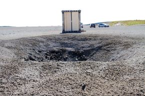 Krater: Et dypt krater og tilsynelatende små skader på platene er resultatet etter detonasjon av 400 kg TNT. <i>Bilde: Joachim Seehusen</i>