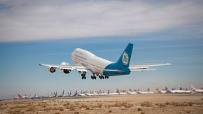 De tre GE CF6-80-motorene på Boeing 747-flyet blir nesten komisk små i forhold til nummer to-motoren, GE9X. <i>Foto:  GE Aviation</i>