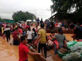 Et stillbilde fra et TV-opptak viser folk som blir evakuert fra det oversvømmede området sør i Laos. <i>Foto:  Attapeu TV via AP / NTB scanpix</i>