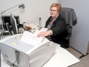 Randi Larsen er en av 30 ansatte ved Oslo Universitetssykehus som skanner papir på heltid - til sammen fem hyllemeter med egenproduserte dokumenter hver uke . Papiret flyttes inn i datasystemer, og gir en liksom-digitalisering. <i>Foto:  Joachim Seehusen</i>