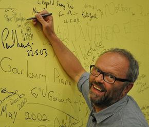 Llewellyn signerer en vegg i forbindelse med en opptreden ved en Linux-konferanse i Australia i 2013. <i>Foto:  Simon Hackett, CC BY-SA 3.0</i>