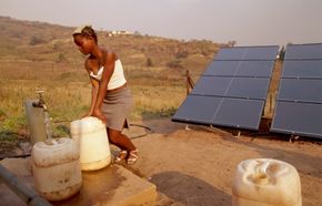 En kvinne henter vann fra en soldrevet vannpumpe i Sør-Afrika. Lokale energiløsninger gir mer for pengene, viser ny rapport. <i>Foto:  Morten Rasmussen</i>