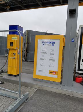Det er noen få meter fra dispenseren til bygningen med elektrolysør og trykkbeholder for lagring av hydrogen under trykk. <i>Foto:  Tore Stensvold</i>