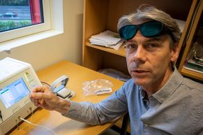 Ledelys: Per Walday viser hvordan laserfiberen kan lyse med svakt grønt lys som kan sees gjennom beskyttelsesbriller for posisjonering. <i>Foto:  Odd R. Valmot</i>