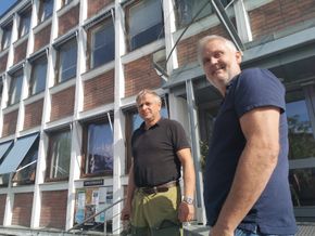 Rådmann Øystein Tveit (t.h) og avdelingsingeniør Olav Kjetil Greivstad foran et kommunehus med til dels store mangler. <i>Foto: Lars Taraldsen</i>