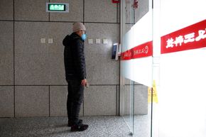 En mann blir identifisert på utsiden av kontoret. <i>Foto:  Thomas Peter/Reuters/NTB Scanpix</i>