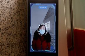 En kvinne får sitt ansikt scannet av systemet, på vei inn på kontoret til Hanwang Technologies. <i>Foto:  Thomas Peter/Reuters/NTB Scanpix</i>