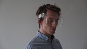 Hågen Toverud viser hvordan brillene festes med et bånd rundt hodet, og dermed kan tilpasses den enkeltes hodeform. <i>Foto:  Eik idéverksted</i>