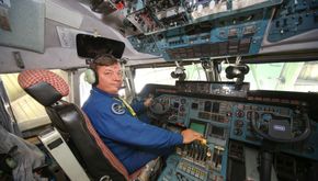 Antonov Airlines-flygeren med en hånd henslengt på de seks gasshåndtakene i An-225-cockpiten. <i>Foto: Bundeswehr/Nato</i>