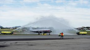 DC-6B LN-SUB, i de originale Braathens SAFE-fargene, møtes med vannsalutt på Sola lufthavn. <i>Foto:  Carina Johansen</i>