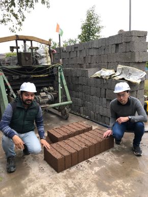 Sandeep Malhotra (Indo Enviro Integrated Solutions Limited) og Christian J. Engelsen (Sintef) viser frem prøveproduksjon av betongblokker med ny type resirkulert tilslag fra Goa. <i>Foto:  Sintef</i>