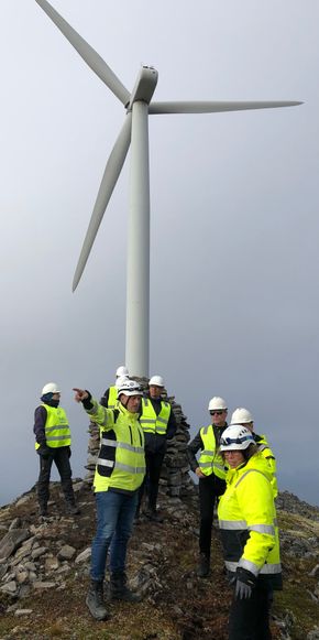 Styre og ledelse i Finnmark Kraft på inspeksjon ved en av de gamle Nordex-turbinene. <i>Foto:  Finnmark Kraft</i>