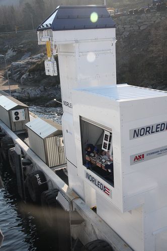 Ladetårn med to systemer. Pluggen er heist opp mens justeringer er i gang på pantografen ved Oppedal ferjeleie. Bilde:  Tore Stensvold