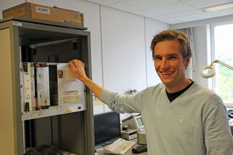 Magnus Jahre, som her viser fram maskinvare som benyttes i forbindelse med testing av prosessorer som er designet ved instituttet. Bilde: Harald Brombach