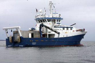 NTNUs forskningsfartøy Gunnerus med FFIs Hugin-container på akterdekk. Ut fra krana henger bredbåndskommunikasjonsutstyret som formidler kontakt mellom moderskip og Hugin. I en kommersiell modell vil det være permanent festet under skipet. Foto: Tore Stensvold