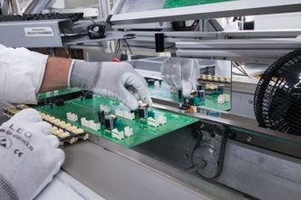 Større komponenter som går gjennom kretskortet, f.eks. releer og spoler, monteres for hånd på samlebåndet. Hver dag går opptil 20 000 kretskort for ulike produkter ut fra fabrikken.