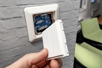 Strømløs og trådløs: Den ser ut som en vanlig lysbryter, men i vippelokket sitter det en EnOcean-sender. Strømmen den trenger for å sende til releet like bak inne i boksen genereres av vippebevegelsen. Releet kan også motta styringsignaler trådløst fra ruteren som kontrolleres av appen. Foto: Futurehome