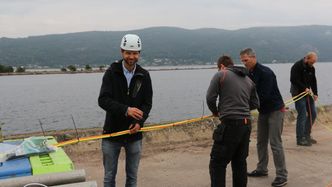 Teknologisjef Joachim Amland (f.v.) og daglig leder Arne Kollandsrud (tredje f.v.) stripser sammen kablene til prototypen. Foto: Roald Ramsdal