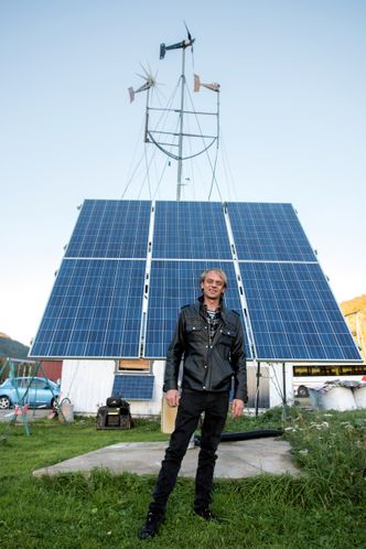 Ruver: Tore Neverås foran det største solcepanelet utenfor huset. Det har en solcelletracker som følger etter sola. Foto: Havard Zeiner