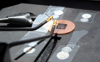 Testes: Ledningene til venstre er koblet til bak-elektroden, hvor strømmen går ut. Den kommer inn igjen gjennom probene på topp-elektroden. Inn og ut går det like mye strøm, ellers ville solcella tømmes for elektroner. Foto: Per Henning, NTNU