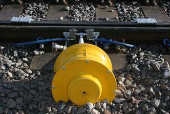 Når toget passerer smøreapparatet presses to tapper ned og frigjør en liten dose med smørefett som fordeles utover skinnene ved hjelp av toghjulene. . Foto: Rovab