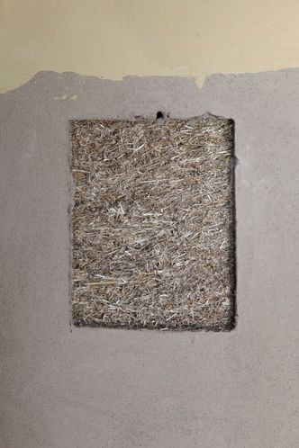 Peters har valgt å beholde et hull i pussen på størrelse med et A4-ark i trappeoppgangen for å kunne vise alle besøkende hva huset faktisk består av. Foto: Mari Gisvold