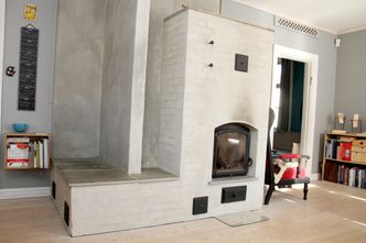 Peisen er ikke en ordinær peis, men en masseovn med to tonn teglstein. Denne magasinerer varmen og gir oppvarming over tid. I en normal mossevinter er det ikke nødvendig å fyre daglig. Foto: Joachim Seehusen