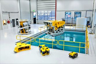 Kystdesigns undervannsroboter i ulike varianter. Til venstre på gulvet foran bassenget ligger den nye notvaskeren. De to minste robotene er observasjons-ROV&#039;er som produseres hos Ocean Robotics i Sverige. Erik Bakkevig eier 25 prosent av bedriften. Foto: Kystdesign