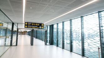 Reisende fra den gamle terminal 2 kommer seg nå dit via den nye broen mellom terminalene. Foto:  Eirik Helland Urke