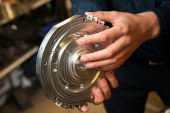 Ventilskiven: Ved pekefingeren til han som holder skiven er ventilen synlig. Den skal etter hvert optimaliseres for forskjellige drivstofftyper. Utviklerne mener at om den utformes korrekt vil det gi samme virkning som en turbo og bidra til økt dreiemoment og effekt, kanskje så mye som 25 prosent. Foto:  Sverre Chr. Jarild