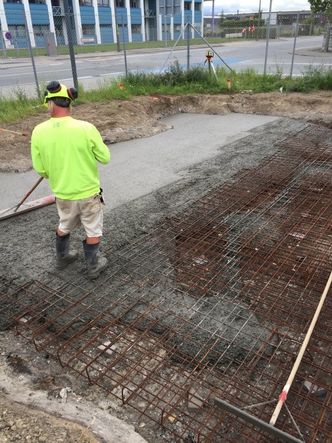 Basisfundamentet er allerede skrevet ut – langs kanten – og deretter armert og støpt. Nå går skriveren i gang med å ekstrudere veggene. Betongblandingen er tradisjonell betong med en tilsetning av gjenbrukt tegl i stedet for grus som det ellers er vanlig å bruke. Teglen forbedrer flyteevnen til betongen, slik at det bare er behov for litt plastifisering. Teglbitene er dessuten så lette at de ikke synker ned gjennom de våte, nyutskrevne betonglagene.  Foto:  3D Printhuset / Arkitekt Ana Goidea