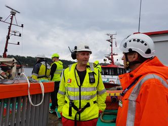 Senioringeniør Jan Willie Holbu i Kystverket (t.h.) i samtale med mannskap fra Kragerø Sjøtjeneste.Selskapet stilte med to slepebåter som la ut ogtestet lenser under Scope 2017. Foto:  Tore Stensvold
