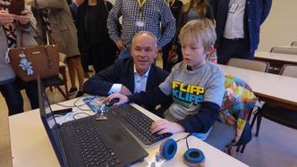 KMD- og IT-minister Jan Tore Sanner får en innføring i koding med micro:bit under fjorårets hack4no. Statsråden vil delta også på årets samling. Foto: Kartverket
