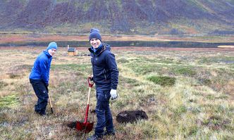 Martin Venås fra Statens vegvesen og Stian Langeland fra Wyssen Avalanche Control Norge graver ned en ny sensor på Kattfjordeidet. Foto:  Statens vegvesen