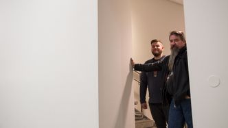 Radiosignalene skal ned fra himlingen og gjennom denne veggen, før de når publikumsområdet. Gunnar Ellingsen i Atea illustrerer utfordringene, her sammen med Nicolai Skoglund, nettverksansvarlig på Astrup Fearnley Museet.