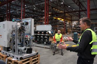 Enheten til venstre er den nye generasjonen ballastvannsystem (BWTS) fra Hyde og PG Flow Solutions. Den er atskillig mer kompakt enn forrige generasjon i bakgrunnen ved siden av Anders Eide. Are Hjertvik (til høyre). Bilde:  Tore Stensvold
