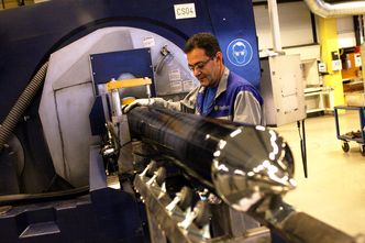 NorSun i Årdal øker produksjonskapasiteten. Her er et operatør med et stykke ingot. Foto:  Peder Qvale